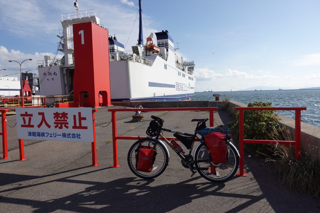 A bicycle with touring gear in front of a ferry.