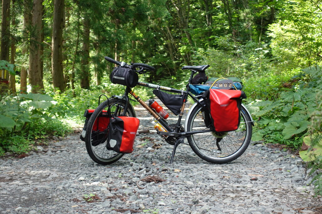 A fully loaded touring bicycle in a forest.